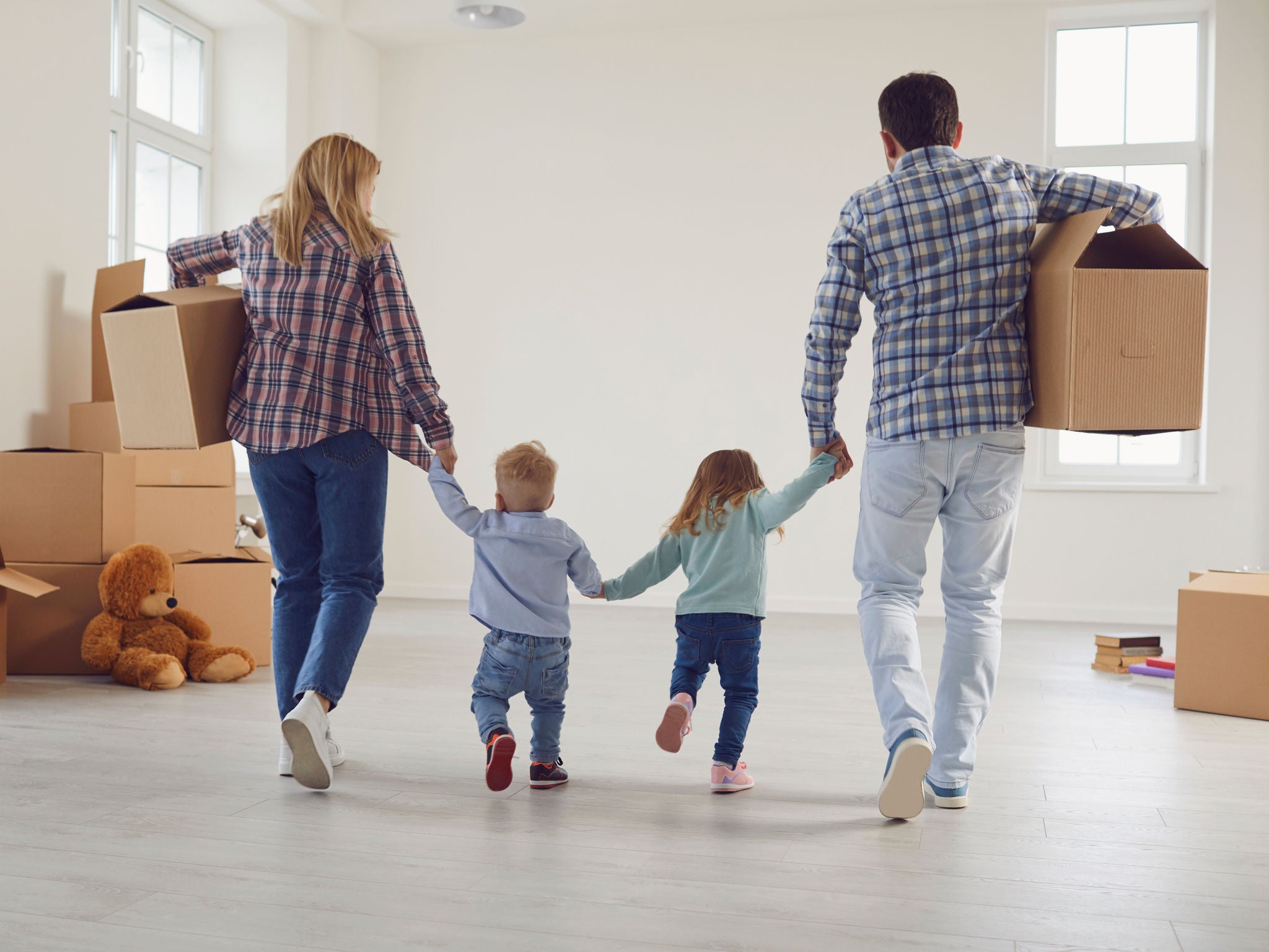 Happy family with children moving with boxes in a new apartment house. Relocation concept new house apartment rental housing.